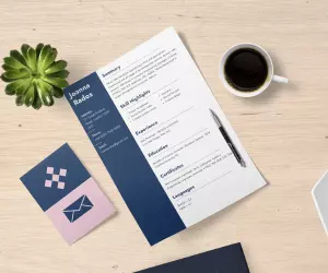 A CV template laid on a table next to a cup of coffee and a plant