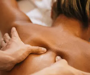 A female performing a back massage on a woman in a spa setting