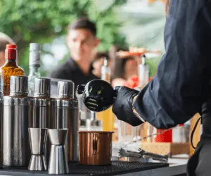 A close up of a bartender making up some cocktails at a bar
