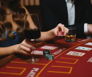 A man and woman sat at a table playing a game of poker