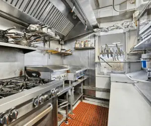 A kitchen featuring a stove and a sink, showcasing a functional cooking and cleaning area