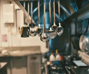 A kitchen featuring various utensils hanging from the ceiling