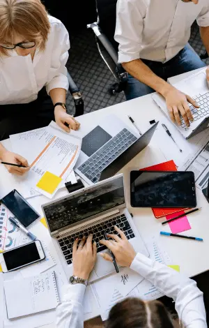 A birds eye view of a group of people sat at a desk working on their computers