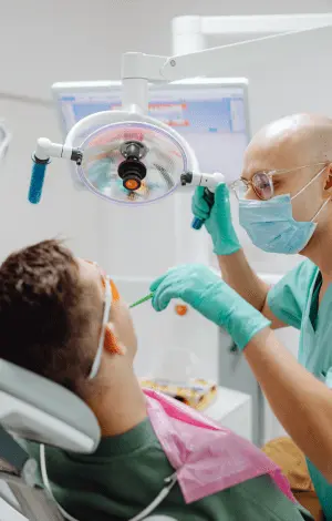 A man seated in a dentist chair, preparing for a dental examination or treatment