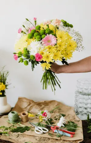 A woman holding a vibrant bouquet of flowers that has created, showcasing floristry