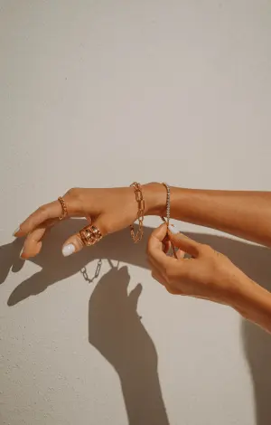 A close-up of a woman showing off her rings and bracelets that she is wearing