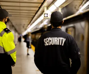a security guard facing his back wearing a black security jacket