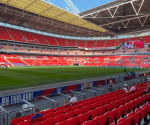 Interior view of a stadium featuring rows of red seats