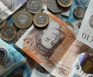 A birds eye view of British notes and coins laid on the table