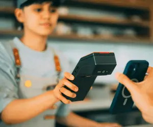 A woman cashier taking a card payment from a customer at a till