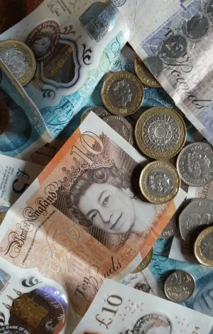 A bird's eye view of British notes and coins laid on a table
