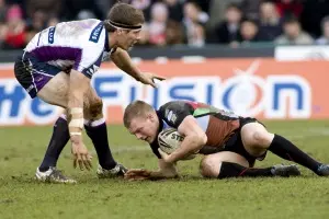 Two men playing rugby in a tackle