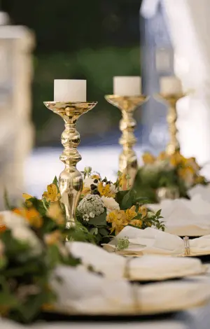 A close up of a table laid with flowers and candles at a wedding