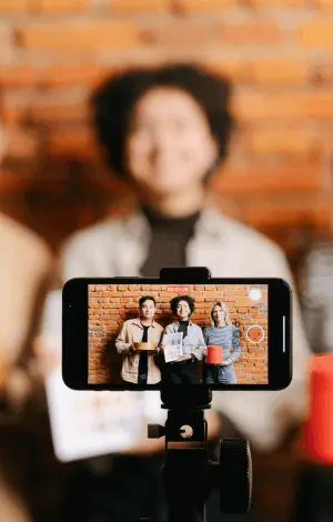 Three people stood in front of a phone camera recording themselves promoting a brands product