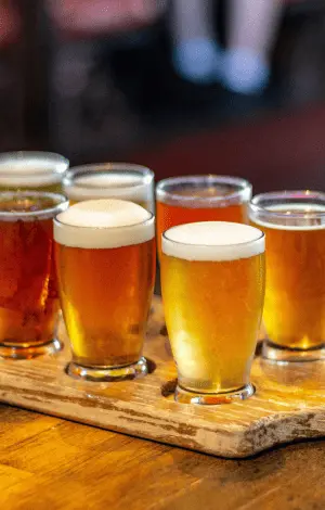 A close up of beers in glasses on a wooden board